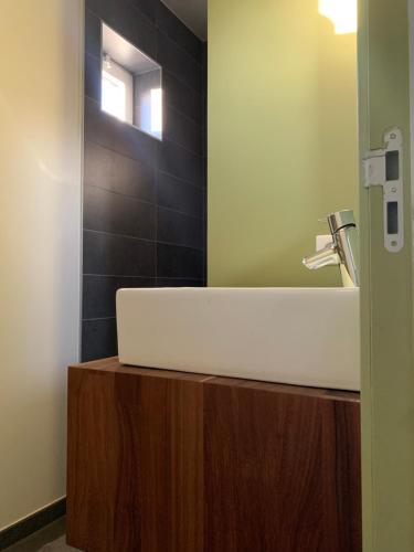 a bathroom with a white sink and a mirror at Maison spacieuse avec piscine au sel proche grand stade in Sainghin-en-Mélantois