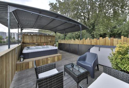 a patio with a bed and a table and a chair at La péniche de Fabrice avec Jacuzzi privatif in Strasbourg