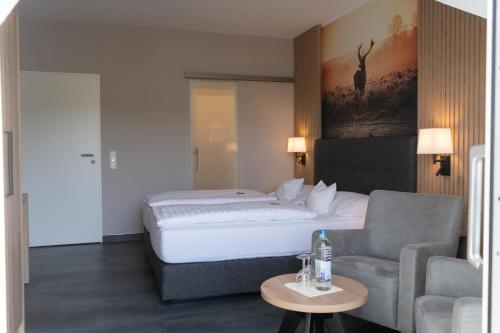 ein Hotelzimmer mit einem Bett und einem Sofa in der Unterkunft Sporthotel Zum Hohen Eimberg in Willingen