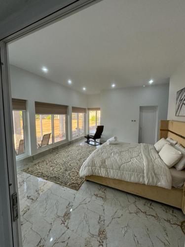 a bedroom with a large bed and a chair at Rashed Farm in Al Rahba