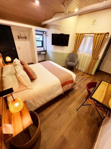 a bedroom with a bed and a desk and a television at Sie Casa Hotel in Villa de Leyva