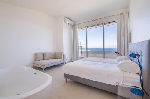 - une chambre blanche avec une baignoire, un lit et une fenêtre dans l'établissement Villa luxe Port d'Alon, à Saint-Cyr-sur-Mer