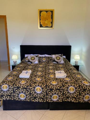 a bedroom with a bed with a comforter and two lamps at Villa Medusa in Tre Fontane