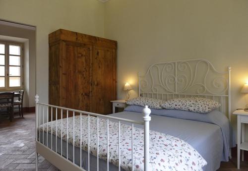 a bedroom with a white bed and a wooden cabinet at Alloro 5 in Marciana Marina