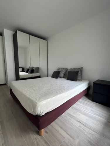 une chambre avec un grand lit avec un grand miroir dans l'établissement Jeux olympiques, à Saint-Denis