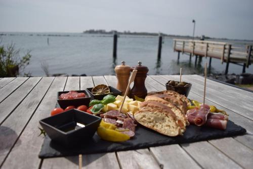 um prato de comida sentado numa mesa perto da água em Kleine-Hafenauszeit em Burgtiefe auf Fehmarn 