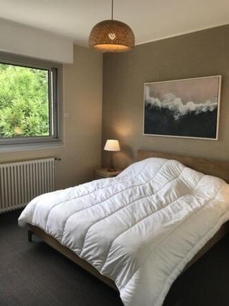 une chambre avec un lit blanc et une fenêtre dans l'établissement Villa Royan, à Royan