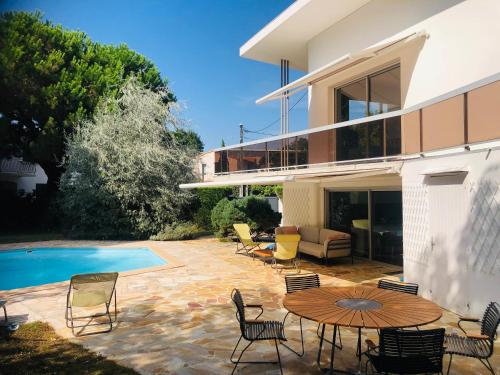 une terrasse avec une table et des chaises à côté d'une maison dans l'établissement Villa Royan, à Royan