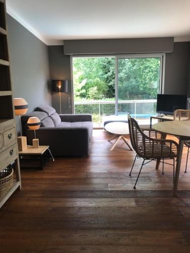 un salon avec un canapé, une table et des chaises dans l'établissement Villa Royan, à Royan