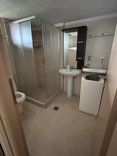 a bathroom with a shower and a sink and a toilet at Stone House in Afytos in Afitos