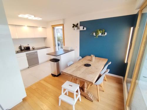 une cuisine et une salle à manger avec une table et des chaises en bois dans l'établissement Penthouse terraces 4 rooms, à Fontenay-sous-Bois