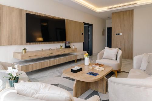 a living room with a table and two chairs and a tv at Swiss International Taif in Taif