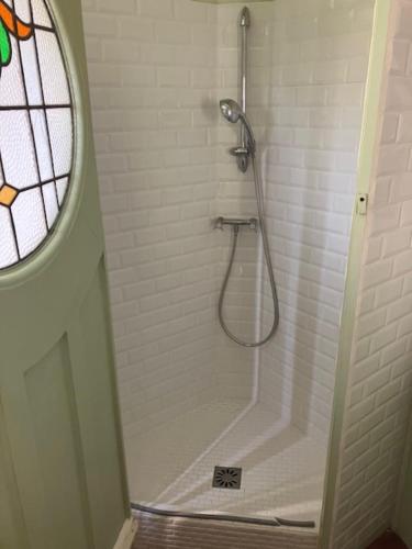 a shower in a white bathroom with a window at cottage à bethemont la foret in Béthemont-la-Forêt