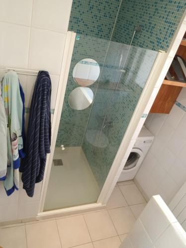 une douche avec une porte vitrée dans une salle de bain dans l'établissement Charmant logement au calme en ville, à Nice