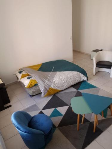 une chambre avec un lit, une chaise et une table dans l'établissement Charmant logement au calme en ville, à Nice