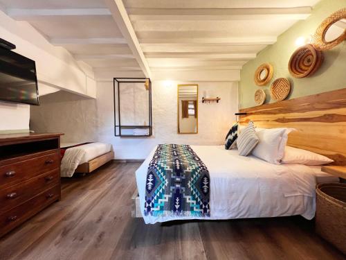 a bedroom with a large bed and a tv at Sie Casa Hotel in Villa de Leyva