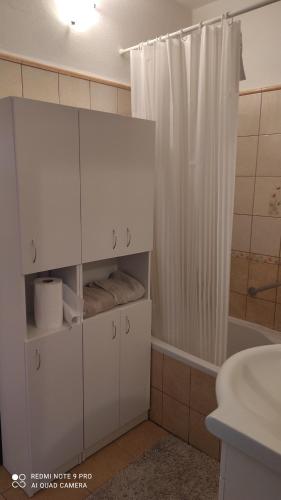 a bathroom with a white cabinet and a shower at Apartmán Sofia in Levice