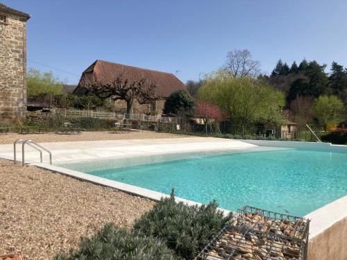 uma piscina num quintal com uma casa em Gîtes des Ecuries de Saint Maurice em Lacapelle-Marival