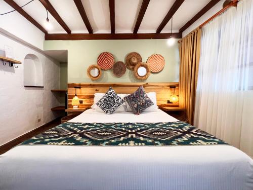 a bedroom with a bed and two baskets on the wall at Sie Casa Hotel in Villa de Leyva
