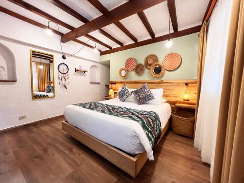 a bedroom with a large bed and wooden floors at Sie Casa Hotel in Villa de Leyva