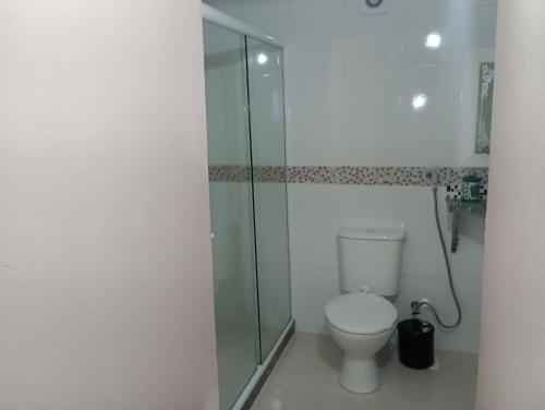 a bathroom with a toilet and a glass shower at Pousada Recanto Das Palmeiras in Búzios