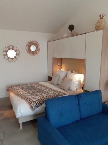 ein Schlafzimmer mit einem großen Bett und einem blauen Sofa in der Unterkunft CHAMBRE D'HÔTES "Le petit Valadas" à 7km d'UZES in Serviers-et-Labaume