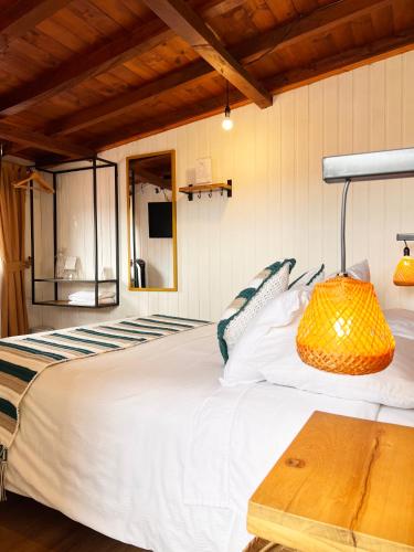 a bedroom with a large white bed and a table at Sie Casa Hotel in Villa de Leyva