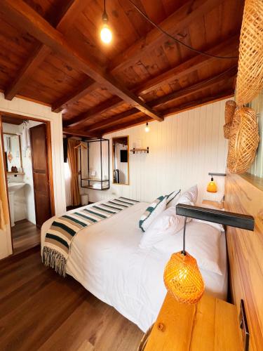 a bedroom with a large bed and a wooden ceiling at Sie Casa Hotel in Villa de Leyva