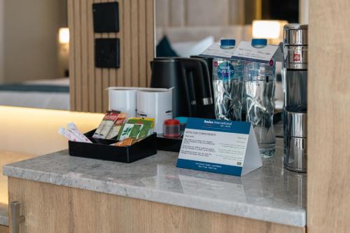 a counter in a hotel room with a sign on it at Swiss International Taif in Taif