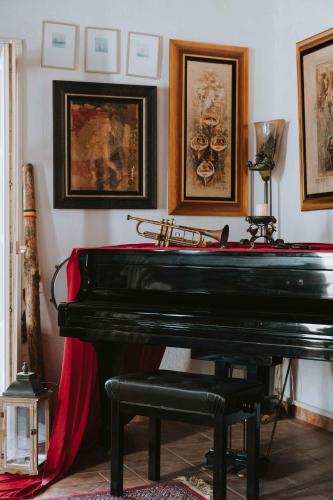 a black piano in a room with pictures on the wall at Studios Kilindra in Astypalaia Town