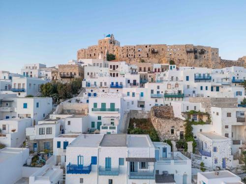 a group of white buildings on a hill with a castle at Studios Kilindra in Astypalaia Town