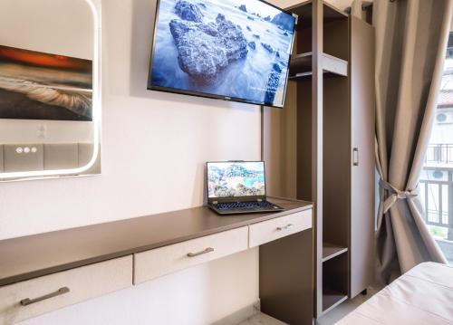 a room with a laptop on a desk with a tv on the wall at Vila Aleka in Nei Poroi