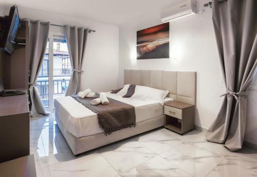 a white bedroom with a bed and a window at Vila Aleka in Nei Poroi