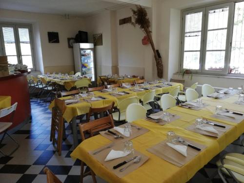 a room full of tables and chairs with yellow tablecloths at Ostello La Miniera in Massa Marittima