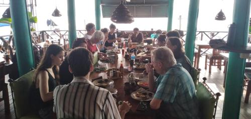 a group of people sitting around a table in a restaurant at Tortugal Boutique River Lodge in Rio Dulce