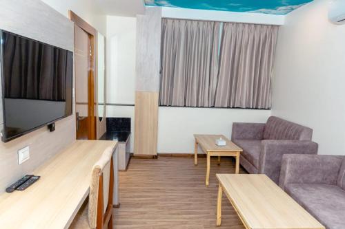 Hotel Badrinath في كاتماندو: غرفة معيشة مع أريكة وتلفزيون