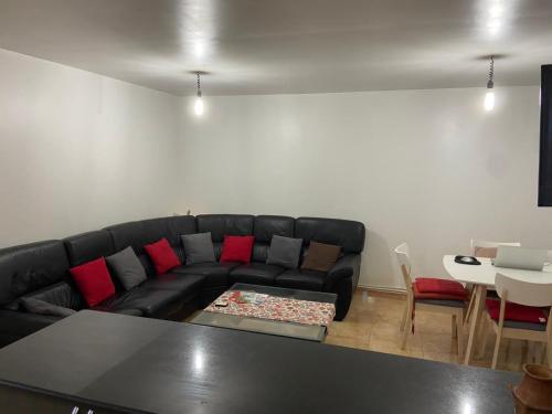 ein Wohnzimmer mit einem schwarzen Sofa und einem Tisch in der Unterkunft Magnifique F3 edimco in Bejaïa