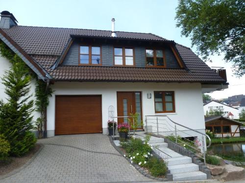 a white house with a brown roof at Cosy apartment with private garden in Brachthausen in the Sauerland in Brachthausen