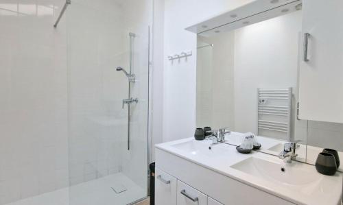 a white bathroom with a sink and a shower at HOME ET HOLIDAY Le Viognier in Viviers