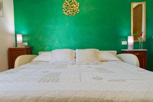 a bedroom with a large bed with a green wall at Villa Mandrioli in Cecina