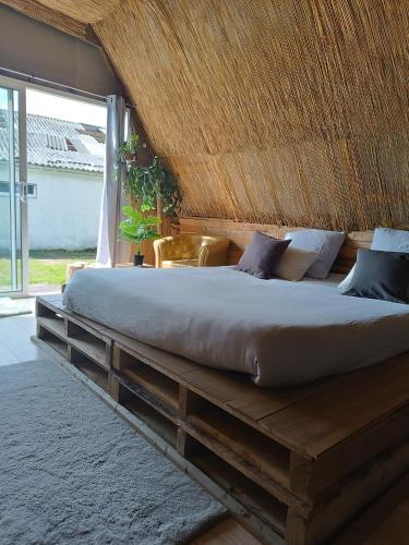 un grand lit dans une chambre avec une grande fenêtre dans l'établissement Cabane Tipi près du phare du Minou en pleine campagne GR34 vélo calme isolé ferme, à Keraugoff