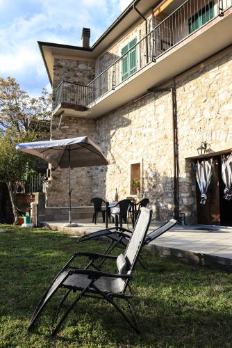 a couple of chairs and an umbrella in a yard at Ca'Toni in Bagnone