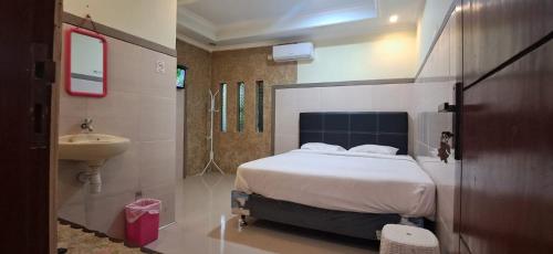 1 dormitorio con 1 cama y baño con lavamanos en CALDERA PARK HOMESTAY Syariah, en Probolinggo