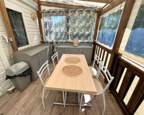 a table and chairs in a tiny house at Mobil home camping Lalande Mimizan in Mimizan