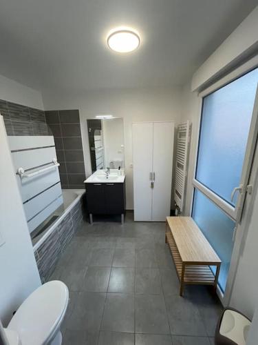 La salle de bains est pourvue de toilettes, d'un lavabo et d'un banc. dans l'établissement Le Qwartz - vue stade de France, à Villeneuve-la-Garenne