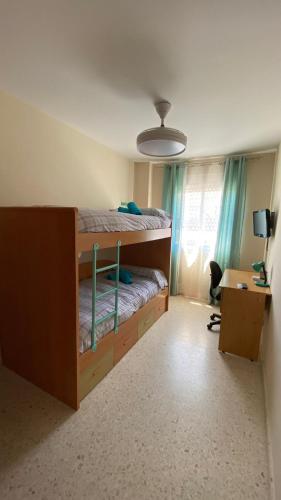 - une chambre avec des lits superposés et un bureau dans l'établissement Puerto Barrio Alto, à El Puerto de Santa María
