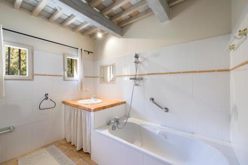 ein weißes Badezimmer mit einer Badewanne und einem Waschbecken in der Unterkunft Apsara in Saint-Saturnin-dʼApt