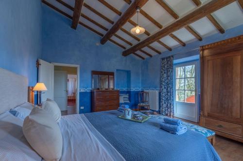 um quarto azul com uma cama grande e uma janela em casale vergheria em Magliano in Toscana