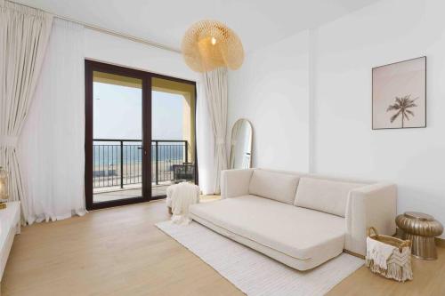 a living room with a white couch and a large window at Beach stylish full sea view in Dubai