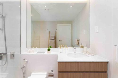 a white bathroom with a sink and a shower at Beach stylish full sea view in Dubai